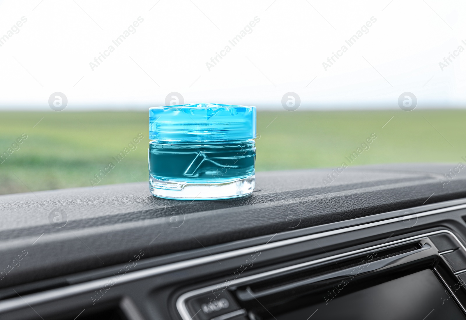 Photo of Stylish air freshener on dashboard in car