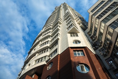 KYIV, UKRAINE - MAY 23, 2019: Modern dwelling building against sky with clouds