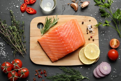 Photo of Fresh raw salmon and ingredients for marinade on black table, flat lay