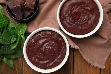 Photo of Delicious fresh fondant, chocolate and mint on wooden table, flat lay