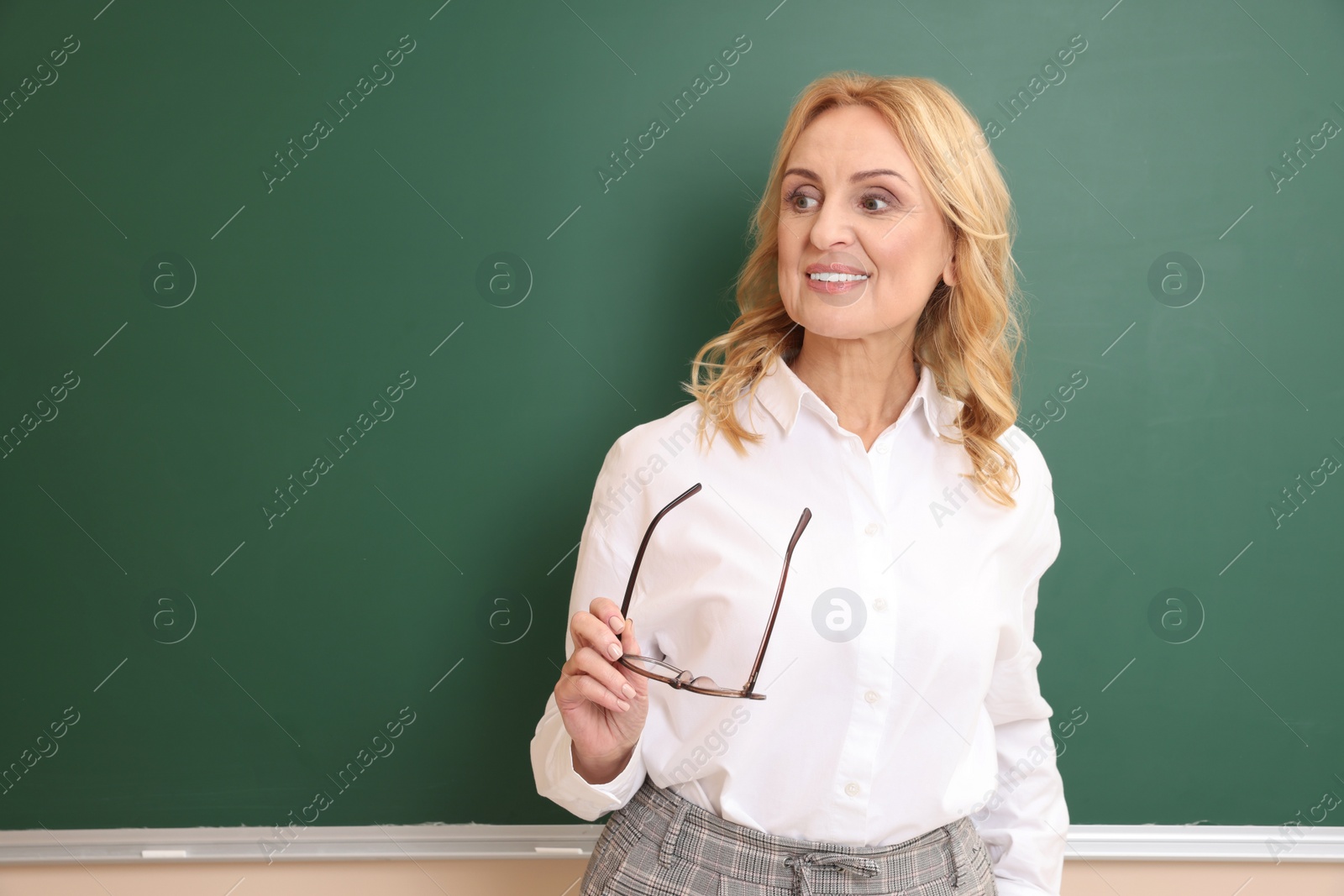 Photo of Happy professor with glasses near green board, space for text