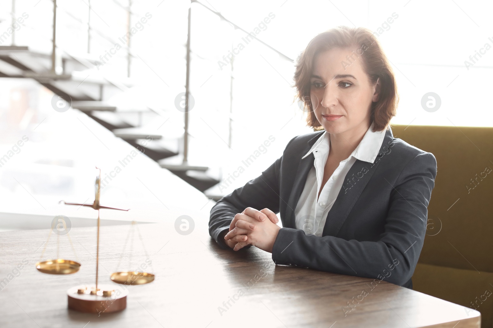 Photo of Scales on table and lawyer in office