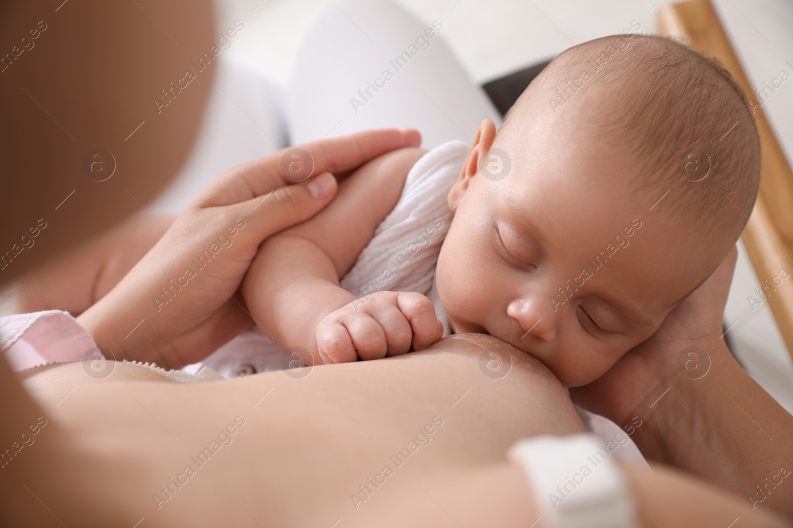 Photo of Woman breastfeeding her cute little baby, closeup