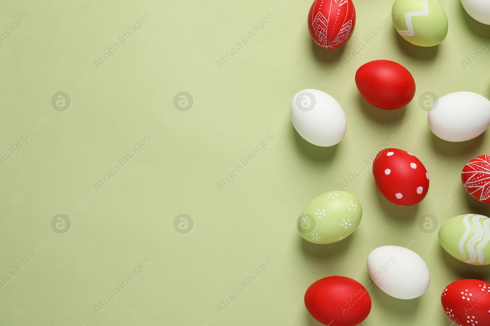 Photo of Flat lay composition with painted Easter eggs on color background, space for text