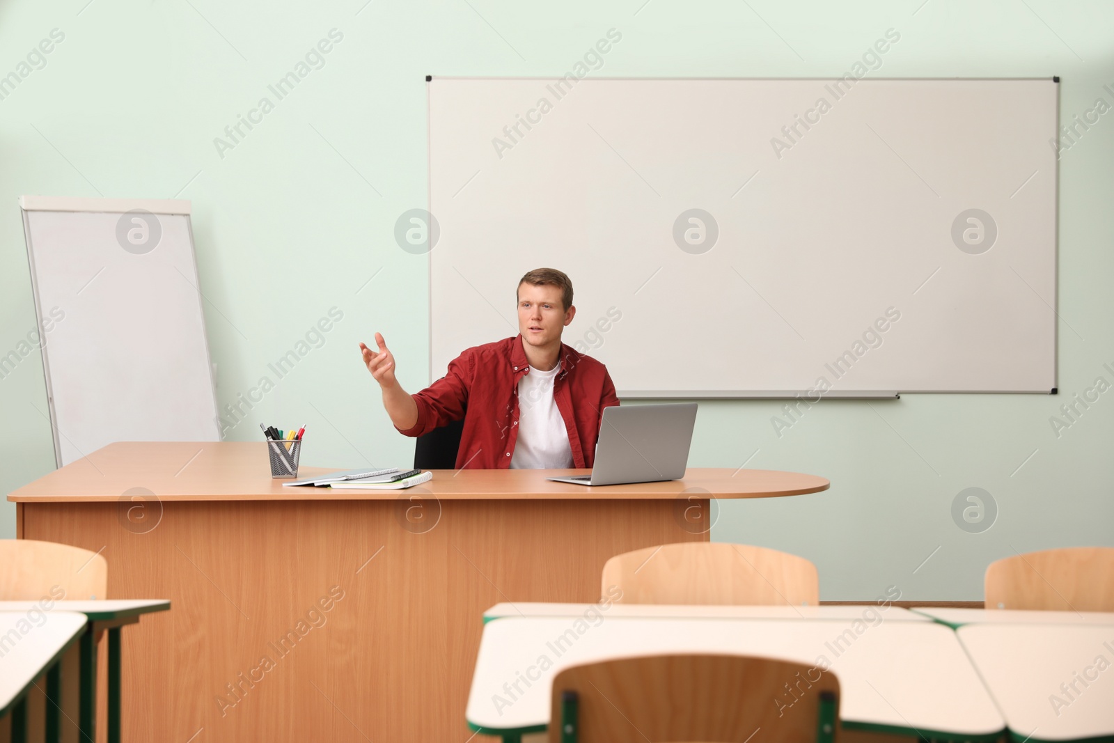 Photo of Male teacher at his desk in classroom