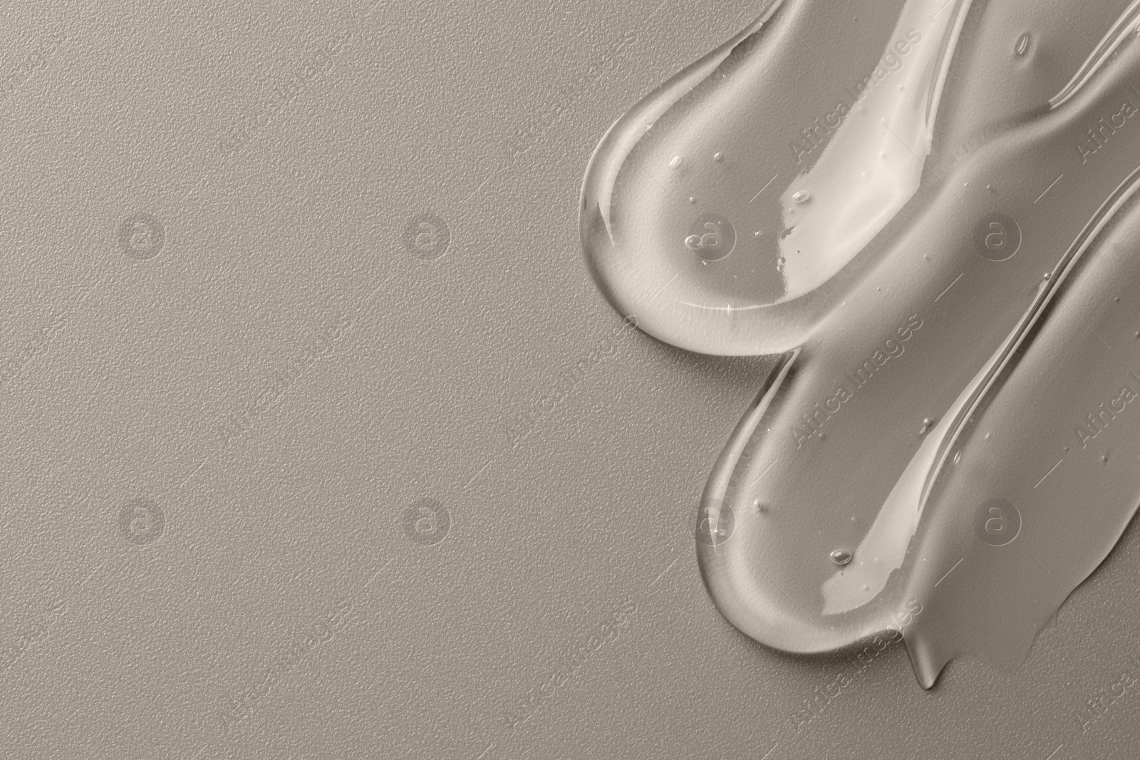 Photo of Sample of clear cosmetic gel on grey background, top view. Space for text