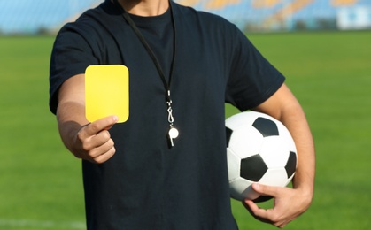 Photo of Football referee showing yellow card at stadium, closeup