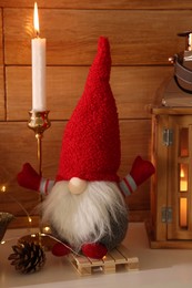 Cute Christmas gnome and festive decorations on mantelpiece in room