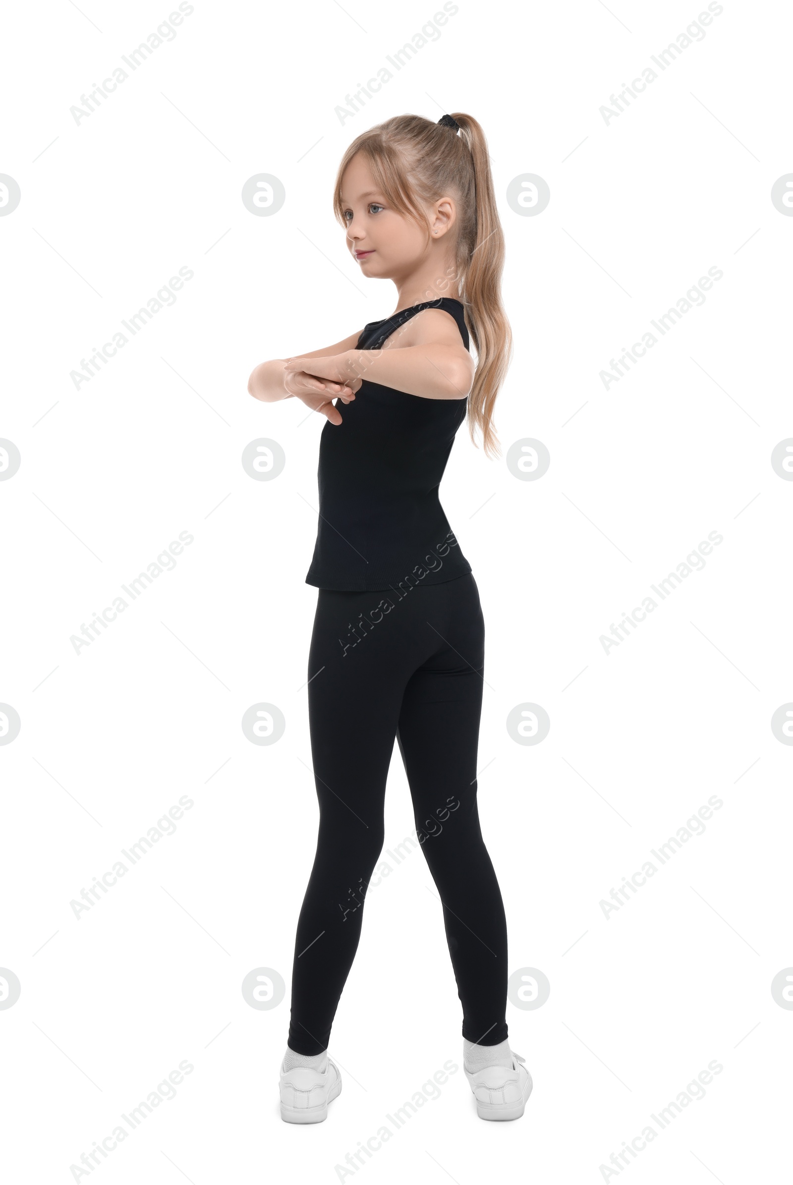 Photo of Little girl doing morning exercise on white background