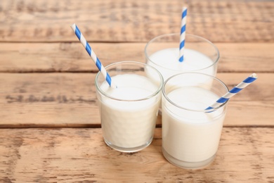 Photo of Glasses of milk on wooden table. Fresh dairy product