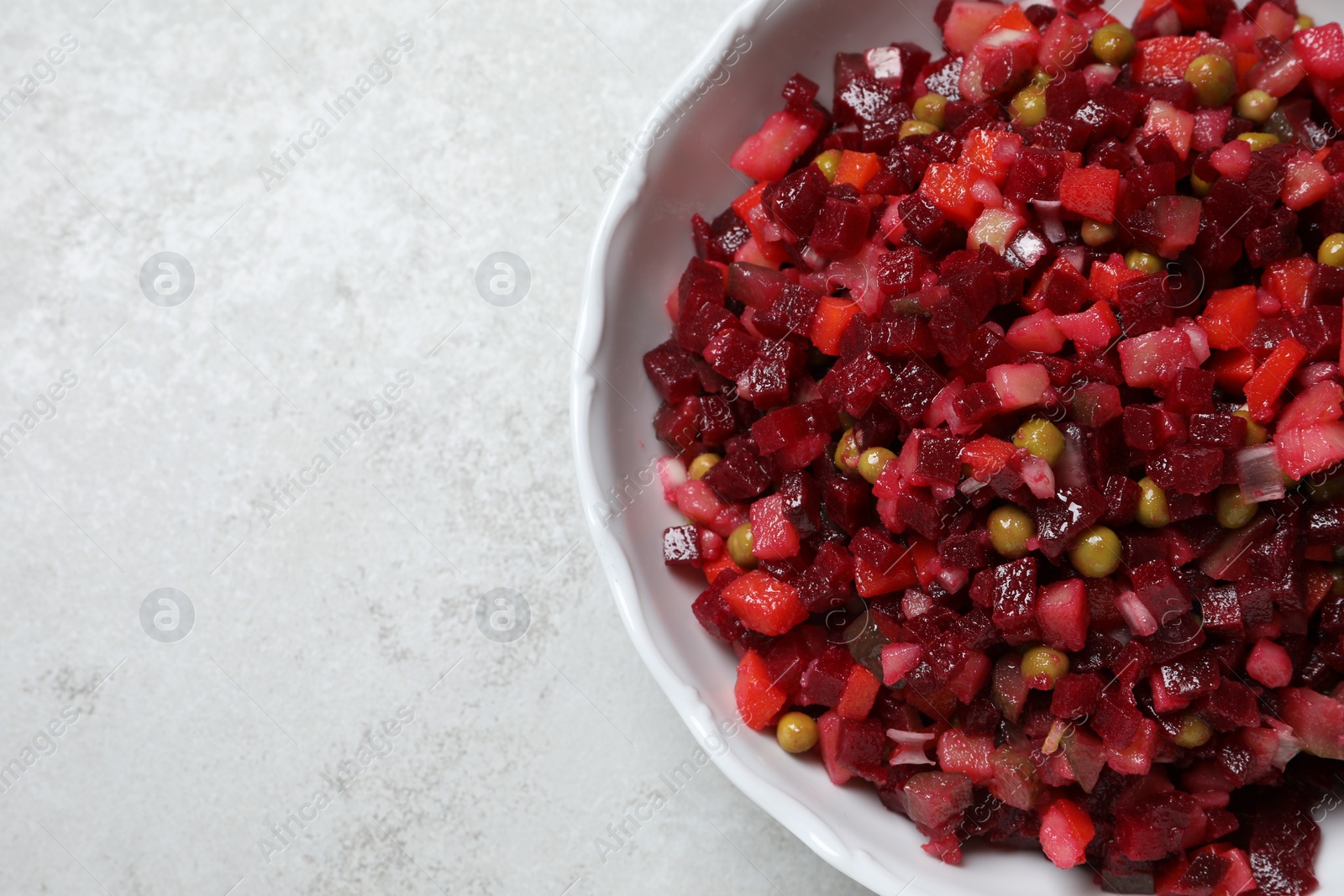 Photo of Delicious fresh vinaigrette salad on light grey table, top view. Space for text