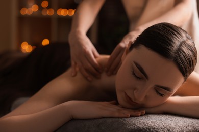 Photo of Spa therapy. Beautiful young woman lying on table during massage in salon