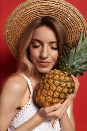 Young woman with fresh pineapple on red background, closeup. Exotic fruit