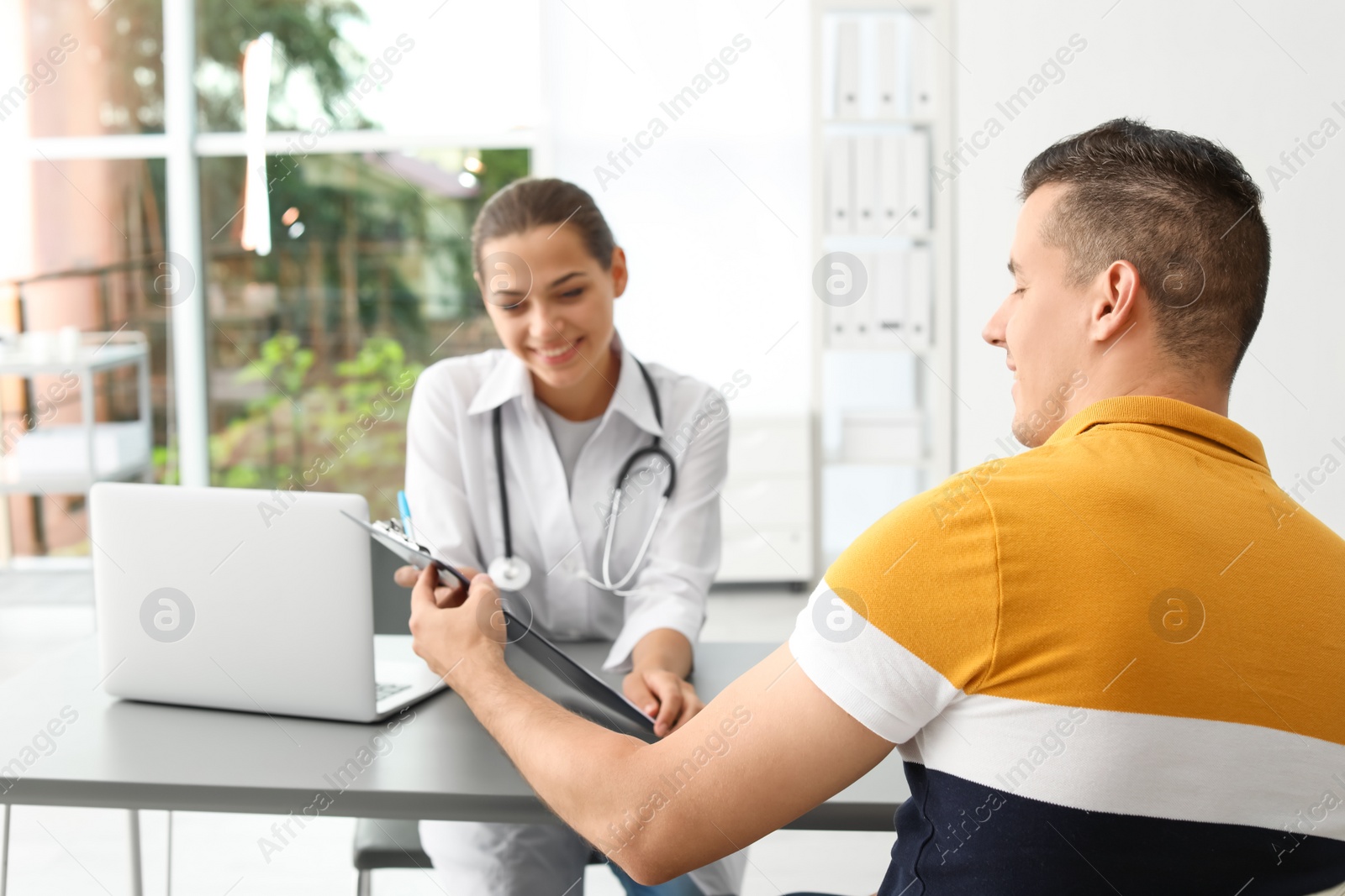 Photo of Young doctor consulting patient in modern hospital