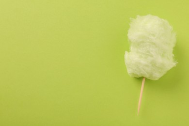 Photo of Sweet cotton candy on green background, top view. Space for text