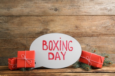 Composition with Boxing Day sign and Christmas gifts on wooden table