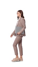 Happy young businesswoman with laptop walking on white background