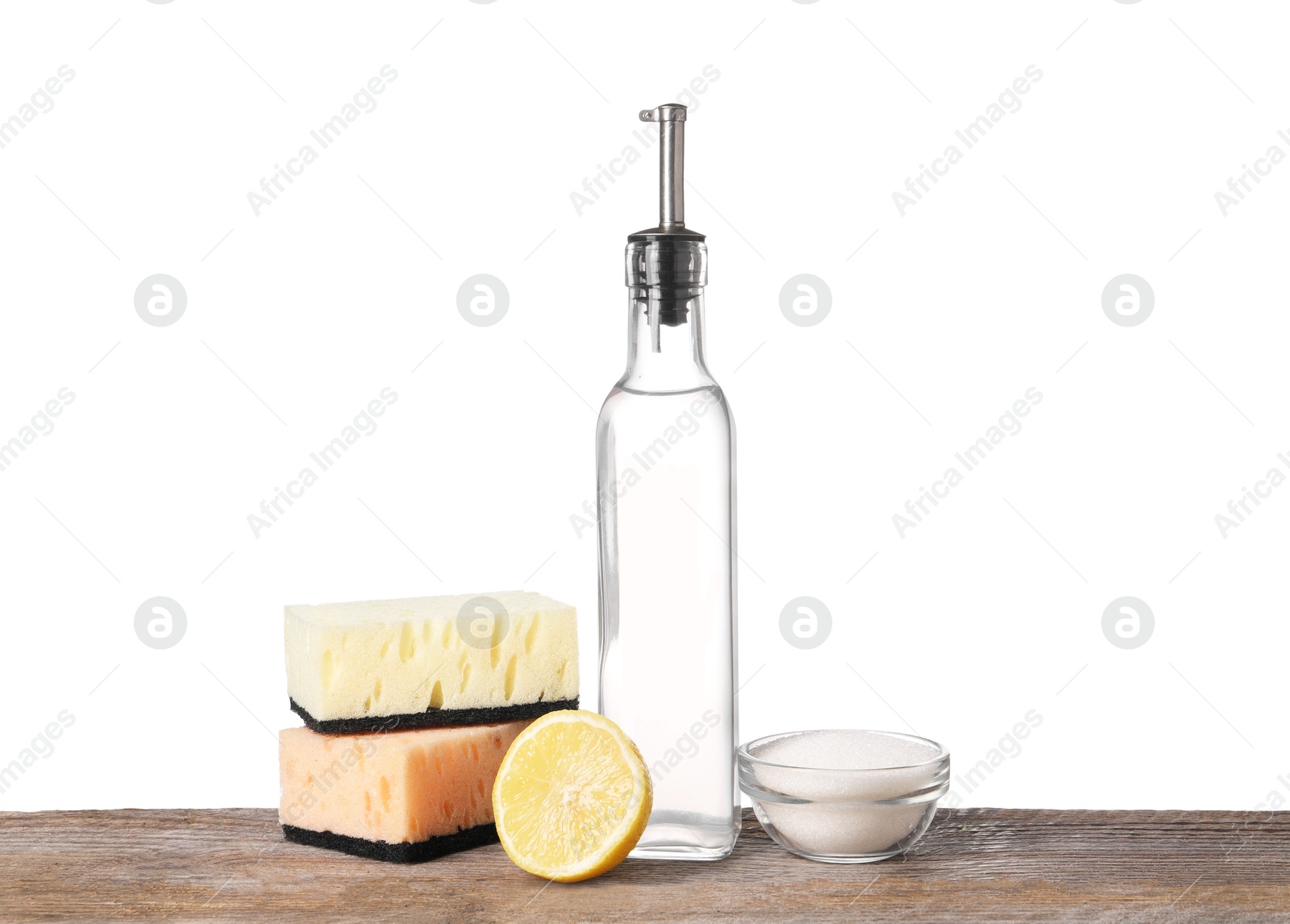 Photo of Natural cleaning products. Vinegar in bottle, baking soda, lemon and sponges on wooden table against white background