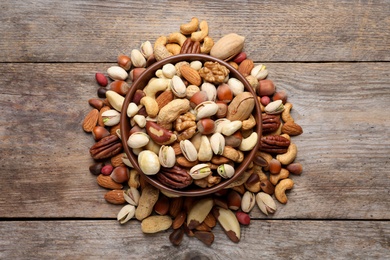 Photo of Flat lay composition with mixed organic nuts on wooden background, top view