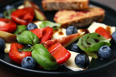 Photo of Delicious salad with brie cheese, berries and balsamic vinegar on table, closeup