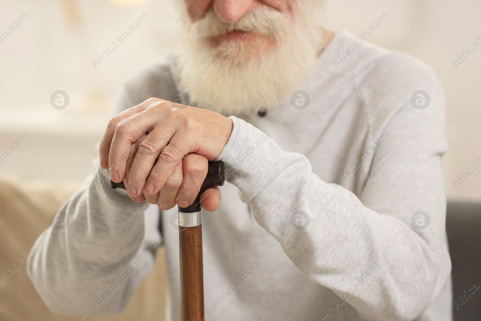 Photo of Senior man with walking cane indoors, closeup