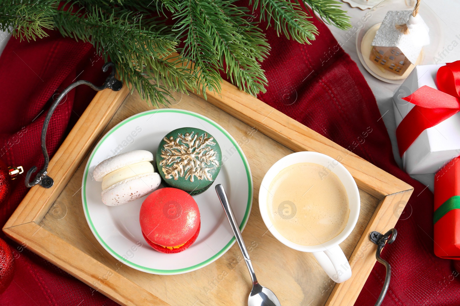 Photo of Different decorated Christmas macarons served with coffee on table, flat lay