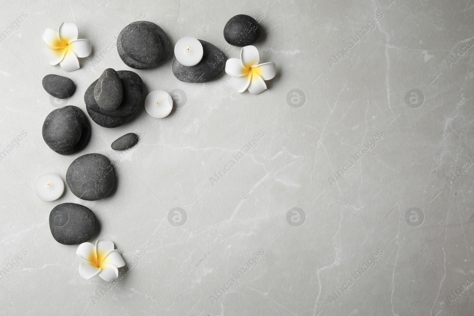 Photo of Flat lay composition with spa stones, candles and space for text on grey background