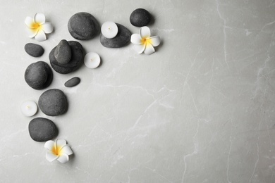 Flat lay composition with spa stones, candles and space for text on grey background