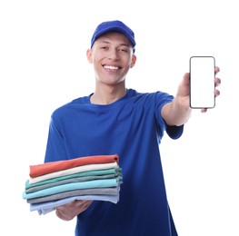 Dry-cleaning delivery. Happy courier holding folded clothes and smartphone on white background