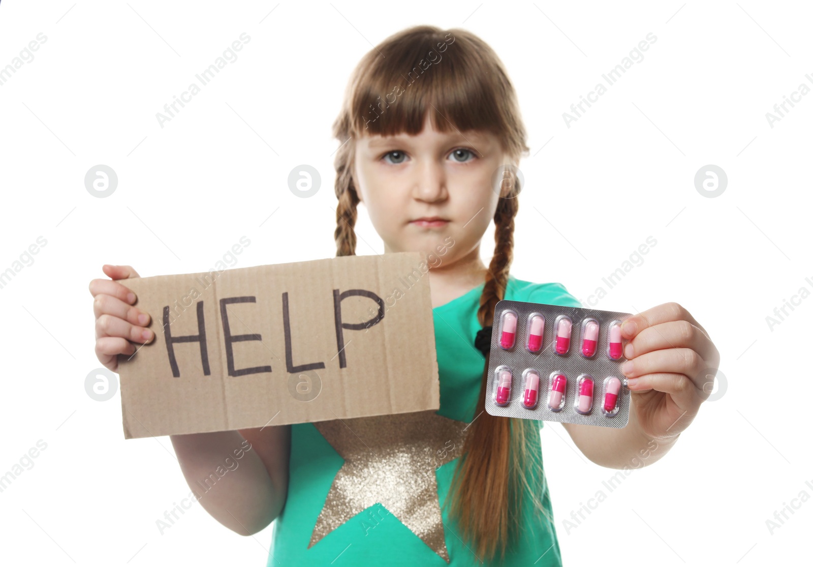 Photo of Little child with pills and word Help written on cardboard against white background. Danger of medicament intoxication