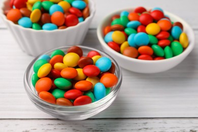 Photo of Tasty colorful candies on white wooden table, closeup