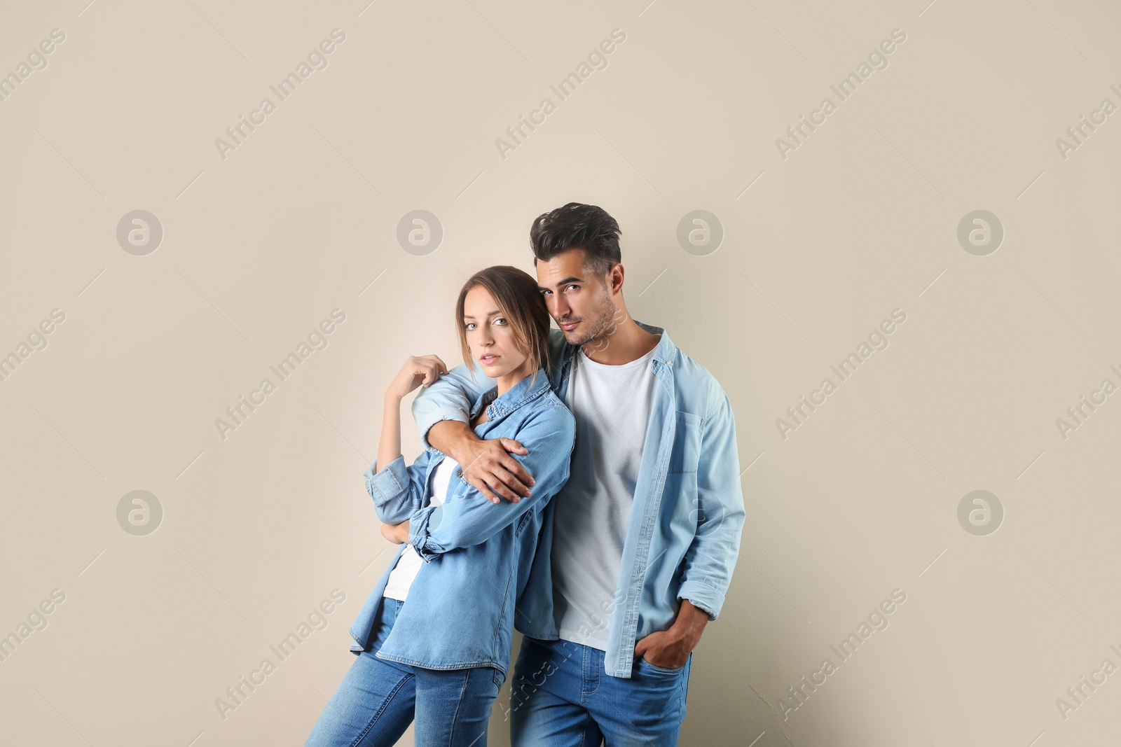 Photo of Young couple in stylish jeans on color background