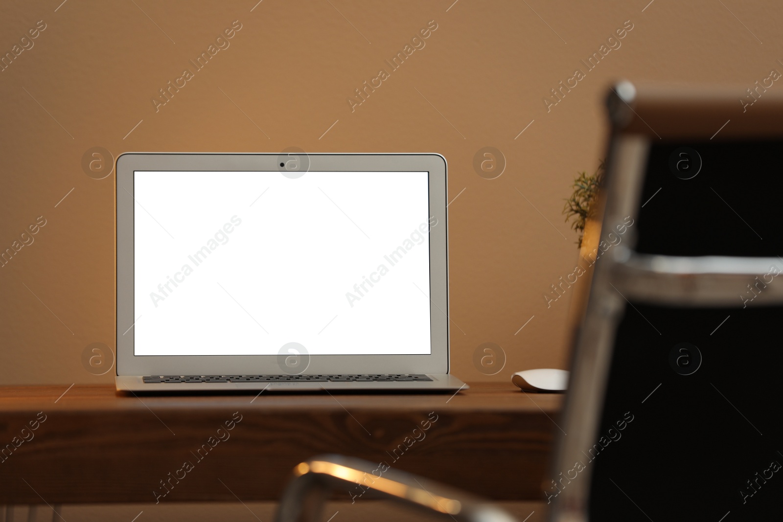 Photo of Laptop with blank screen on table indoors. Space for text