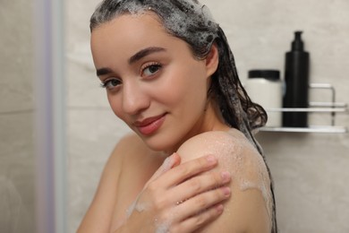 Photo of Portrait of beautiful woman washing hair in shower