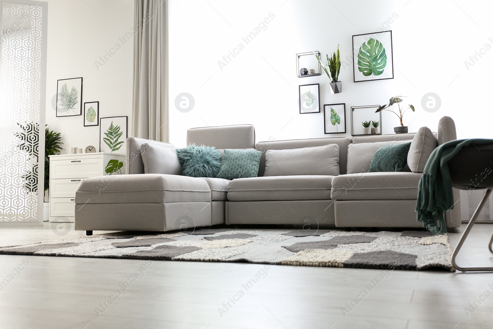 Photo of Comfortable large sofa in light room. Interior design
