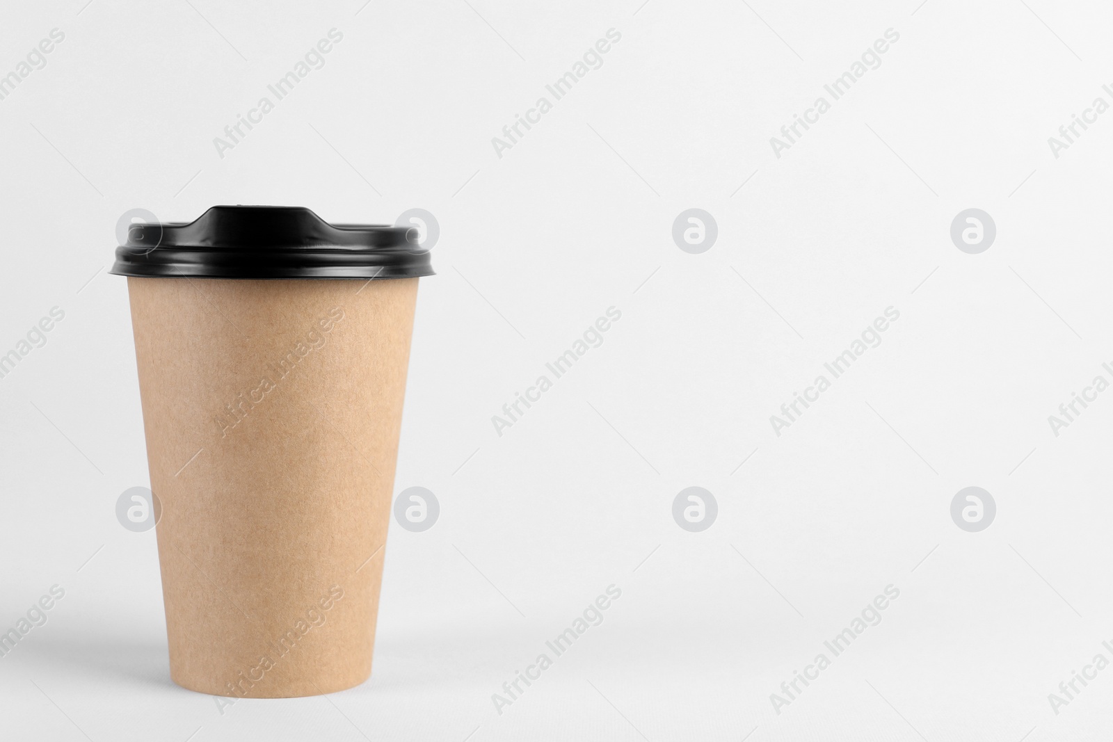 Photo of Paper cup with plastic lid on light background, space for text. Coffee to go