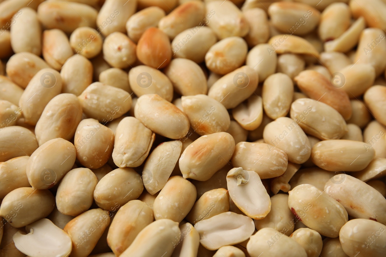 Photo of Many roasted peanuts as background, closeup view