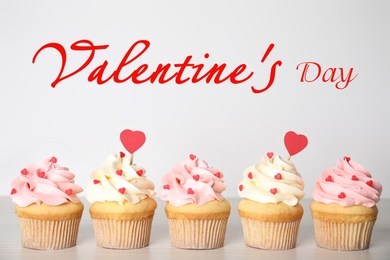 Image of Tasty sweet cupcakes on white table. Happy Valentine's Day