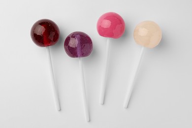 Tasty lollipops on white background, flat lay