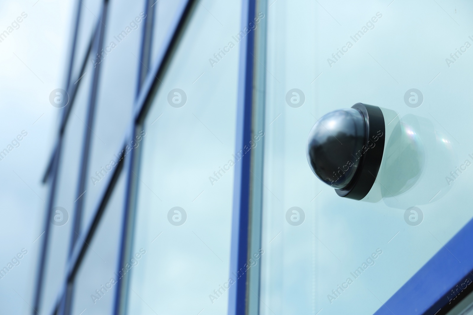 Photo of Modern CCTV security camera on building wall outdoors. Space for text