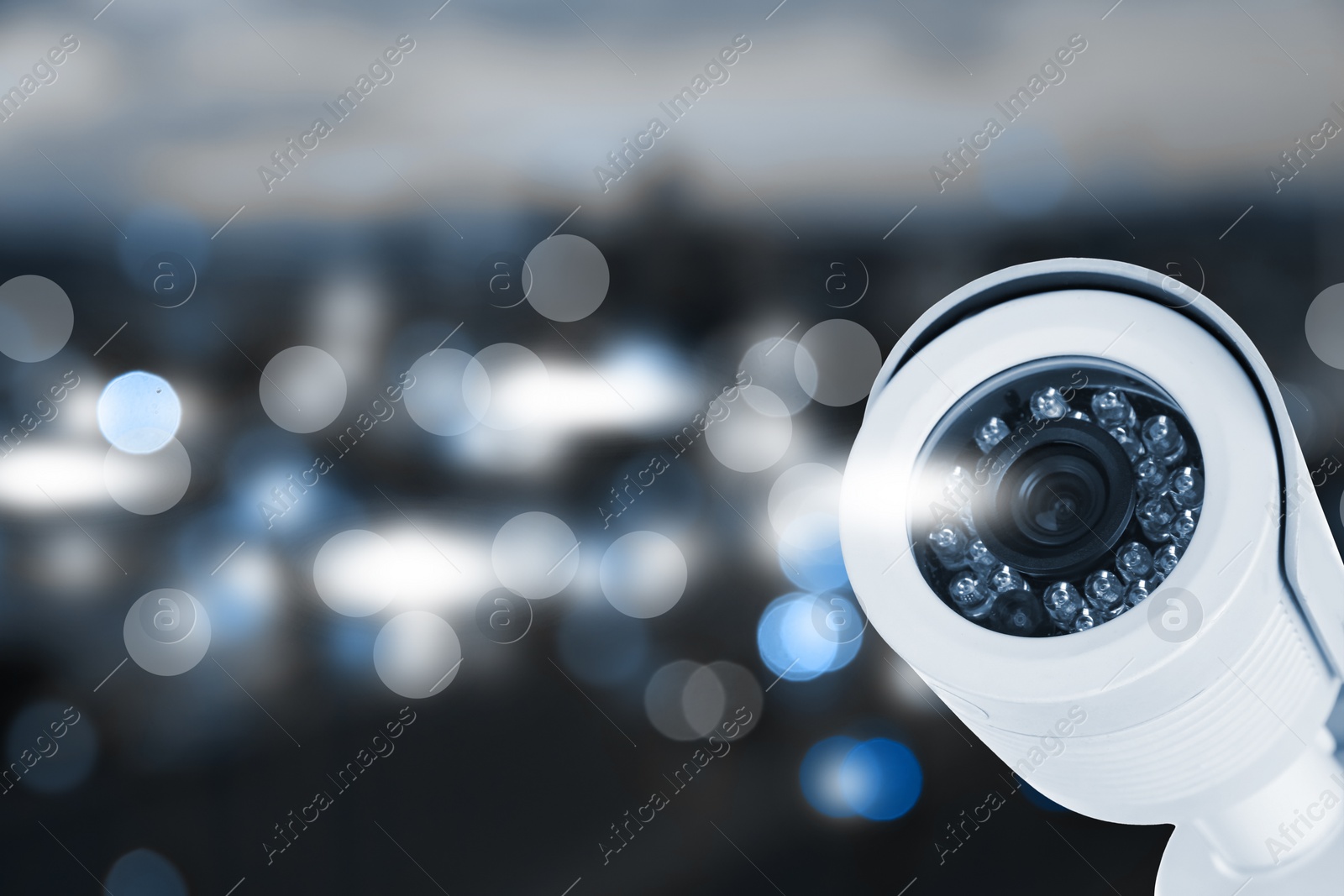 Image of Modern security CCTV camera against blurred background, space for text