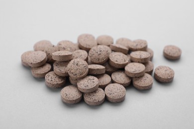 Photo of Brewer`s yeast tablets on light grey background, closeup