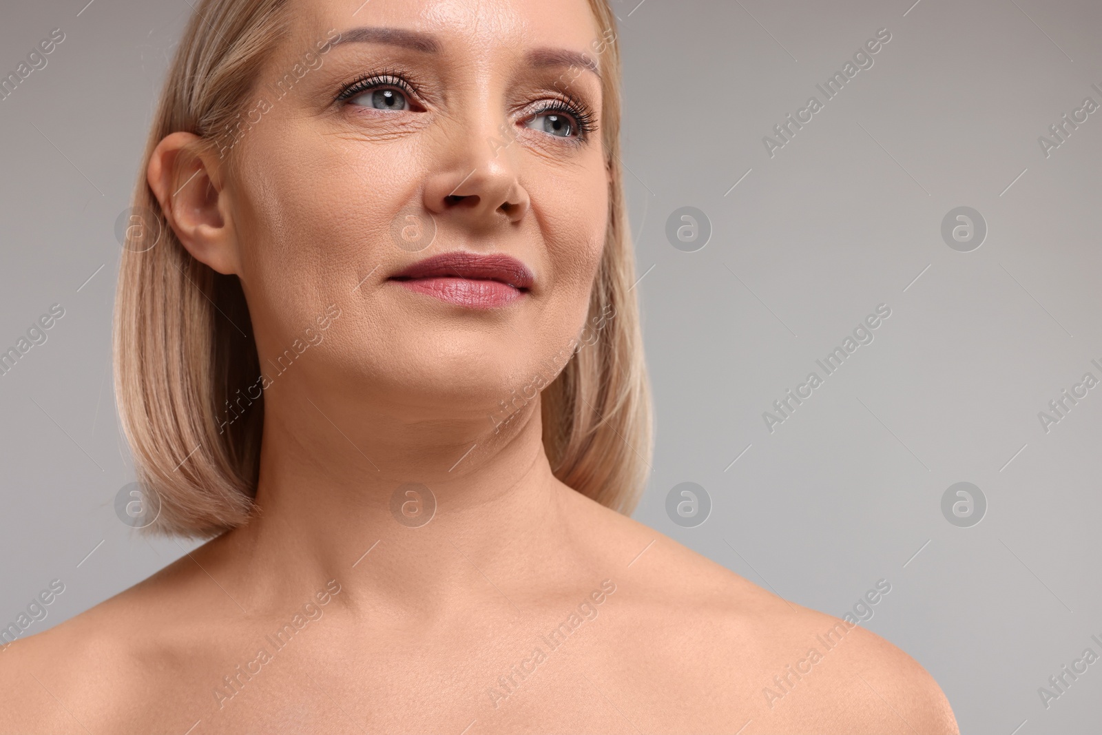 Photo of Beautiful woman with healthy skin on grey background, closeup