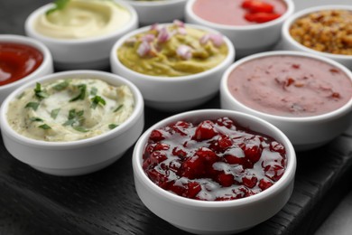 Photo of Different tasty sauces in bowls on table, closeup
