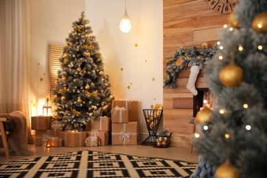 Photo of Stylish room interior with beautiful Christmas tree and gift boxes