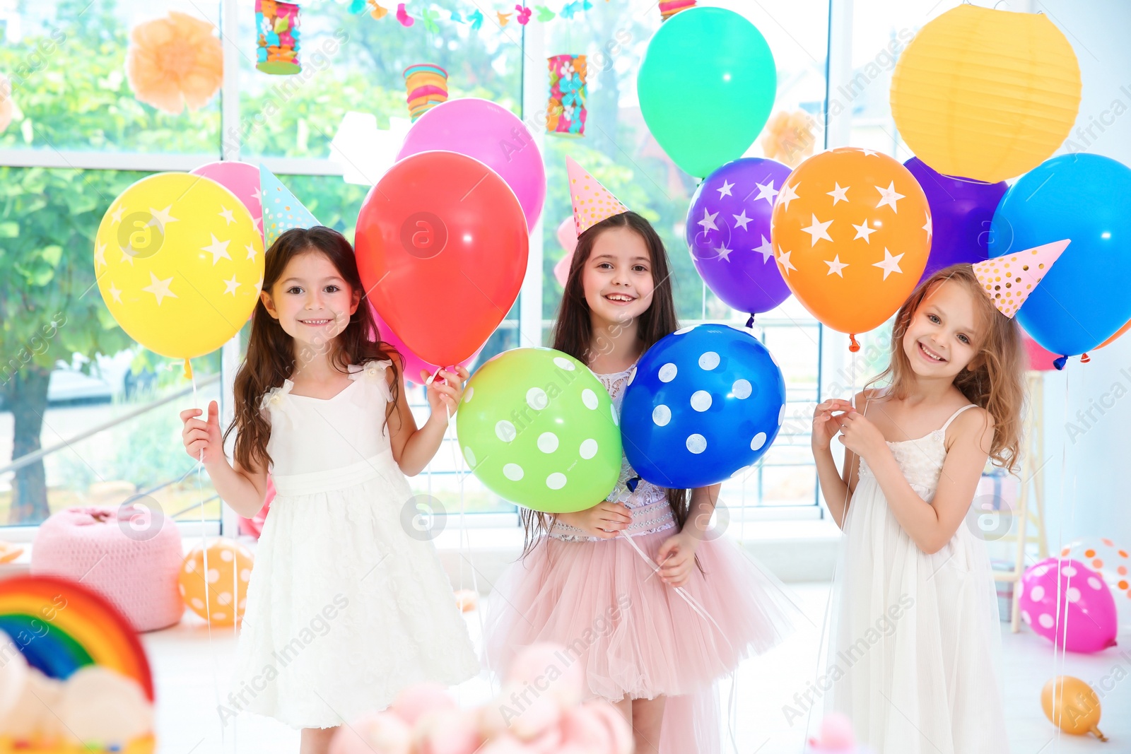 Photo of Cute girls with balloons at birthday party indoors