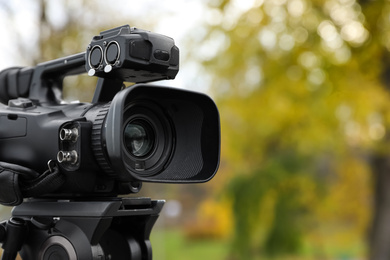 Photo of Professional video camera outdoors. Space for text