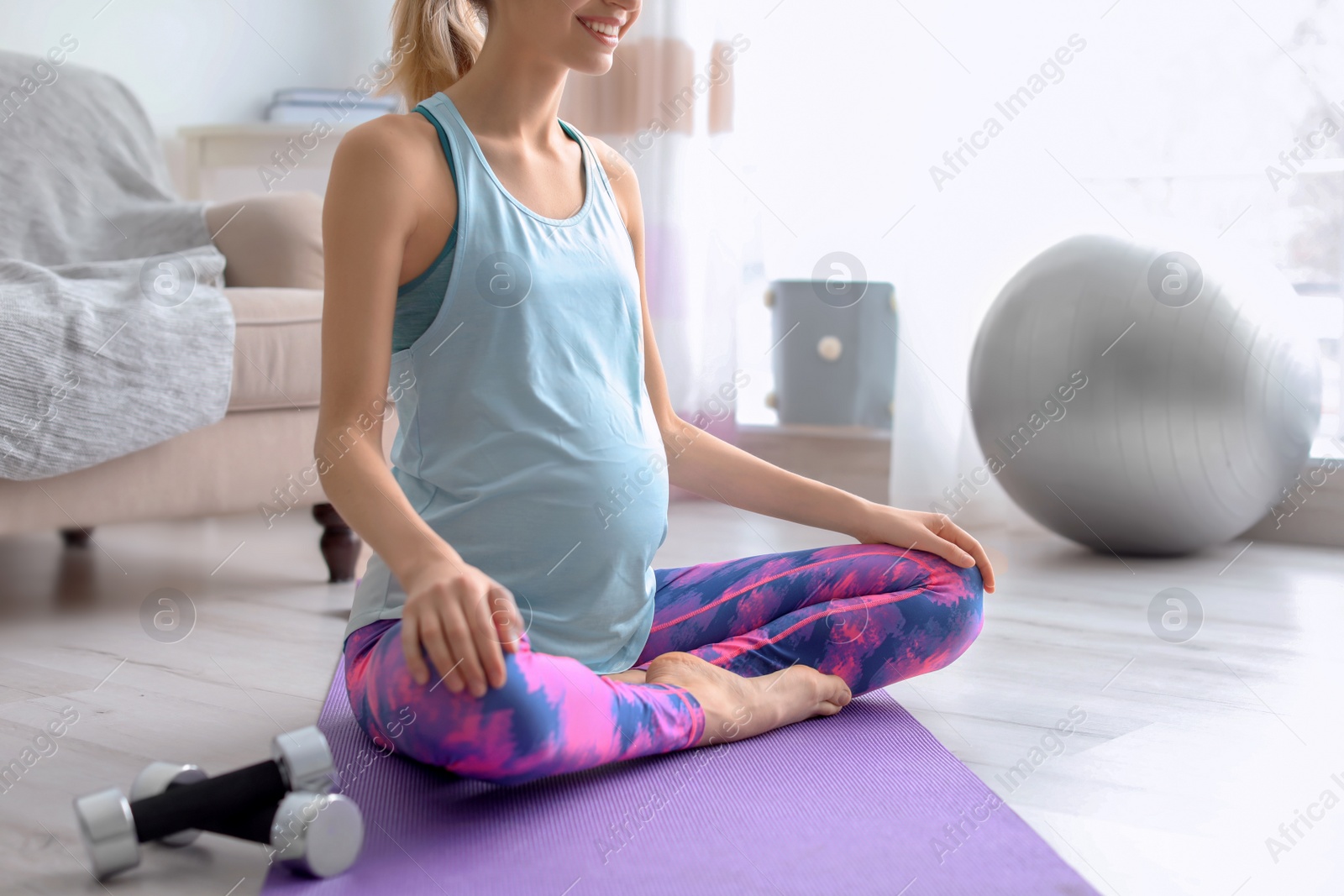 Photo of Young pregnant woman doing exercises at home