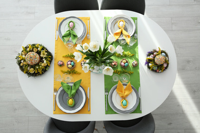 Photo of Festive Easter table setting with beautiful tulips and eggs, top view