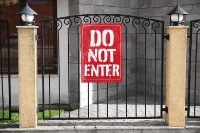 Image of Sign with text Do Not Enter on metal fence outdoors
